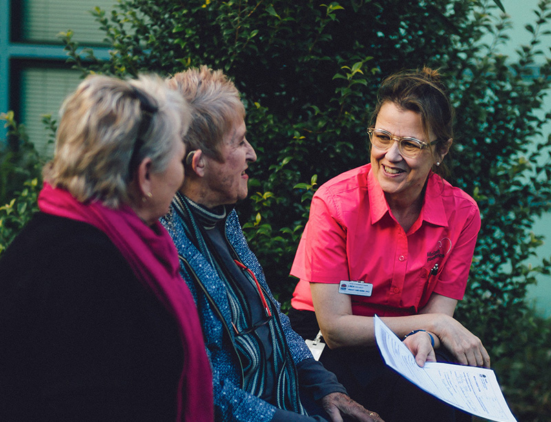 A McGrath nurse talking to two women