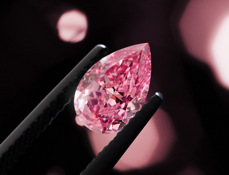 A pink diamond in tweezers