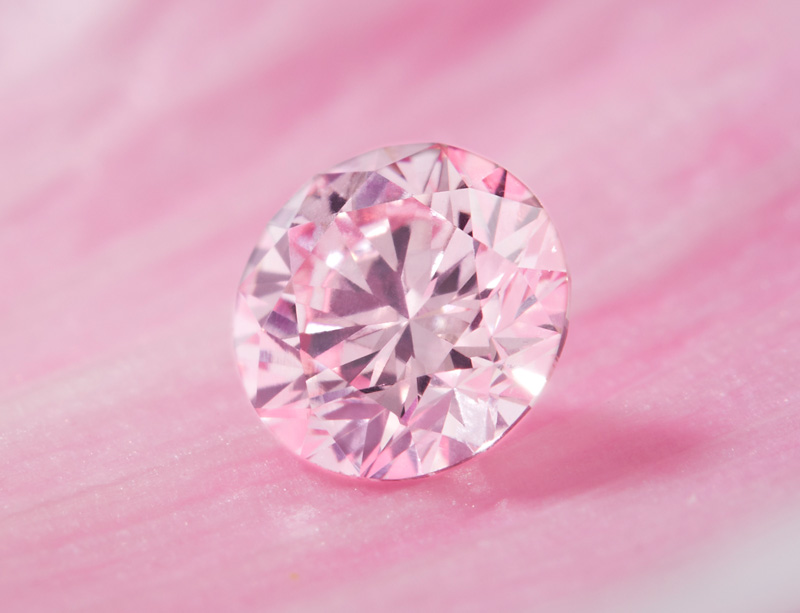 A pink diamond sitting on a pink petal